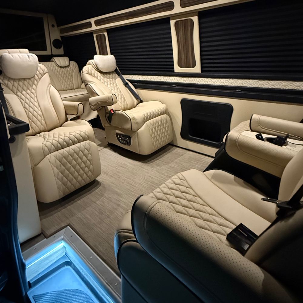 The cabin with four quilted captain's chairs, privacy shades, a side console and a lit entry step